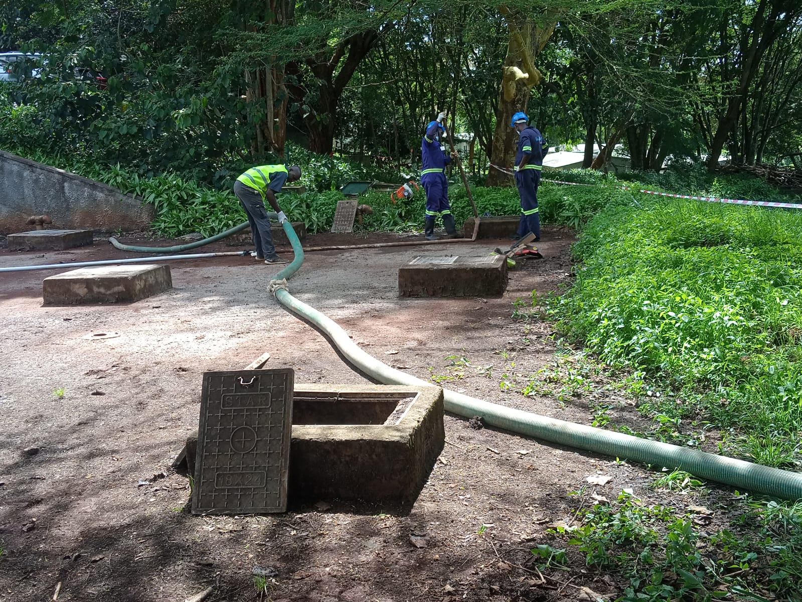 Omidrop Africa field technician handing a NEMA-compliant septage disposal certificate to a building manager after completing a commercial septic tank siphoning job in Nairobi
