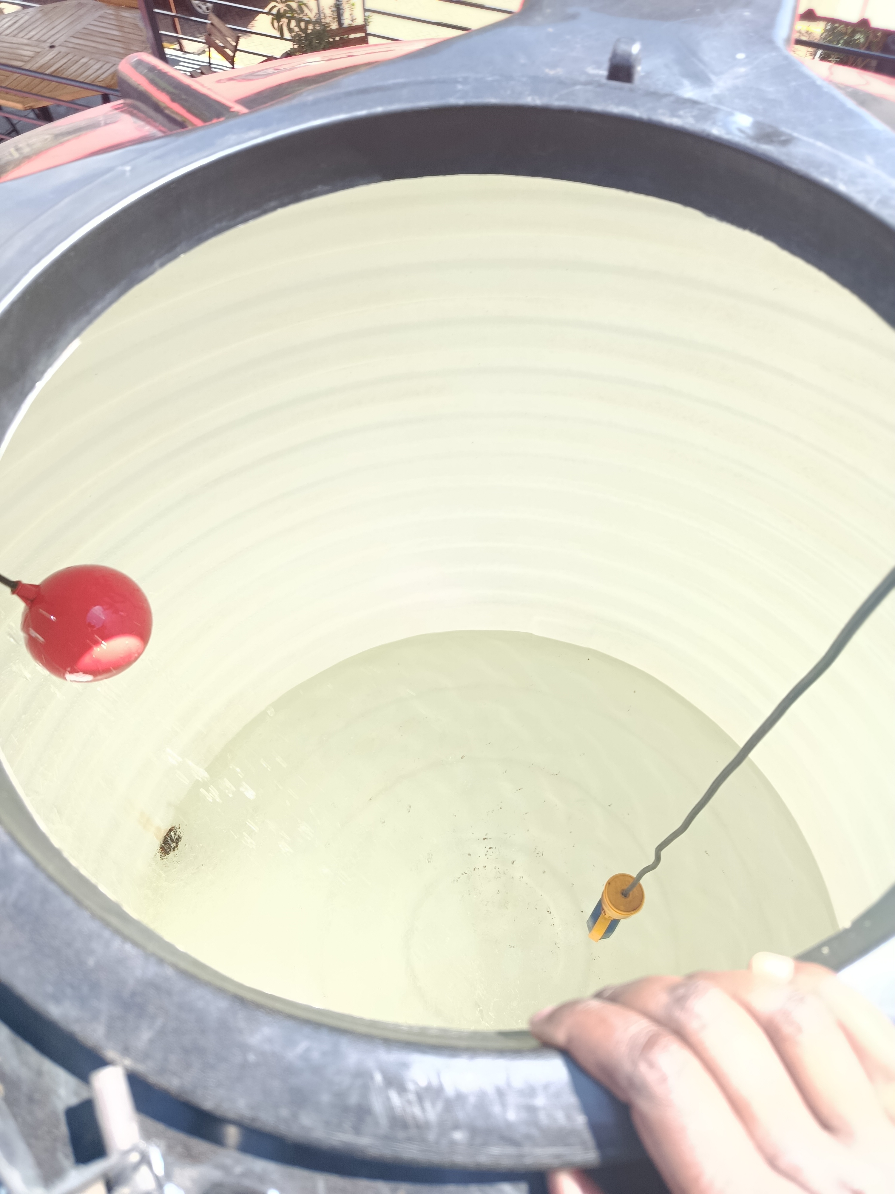 Omidrop Africa technician performing interior scrubbing inside a large concrete water tank in Nairobi, Kenya, during a professional water tank cleaning service