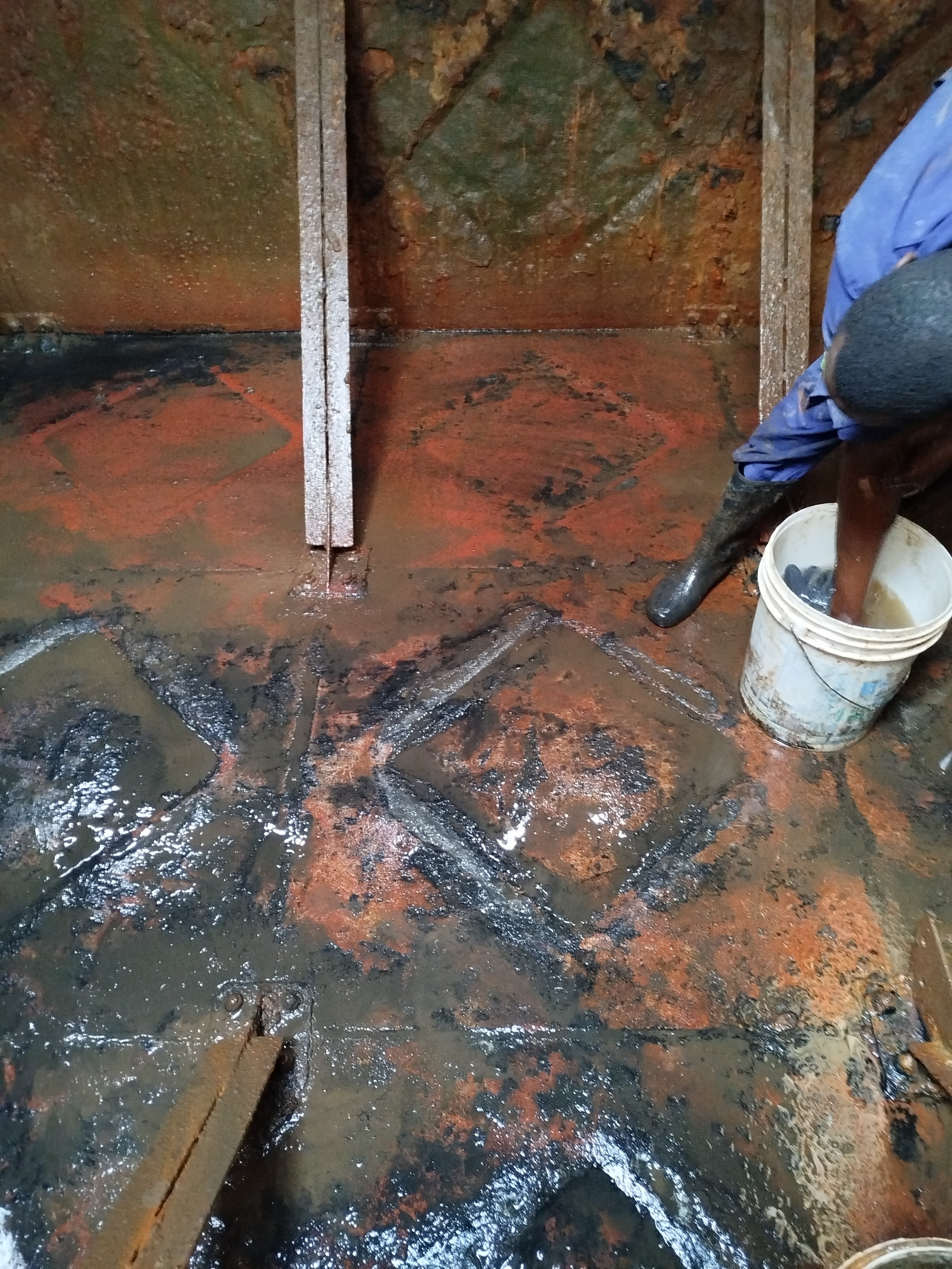 Omidrop Africa technician performing interior scrubbing inside a large concrete water tank in Nairobi, Kenya, during a professional water tank cleaning service